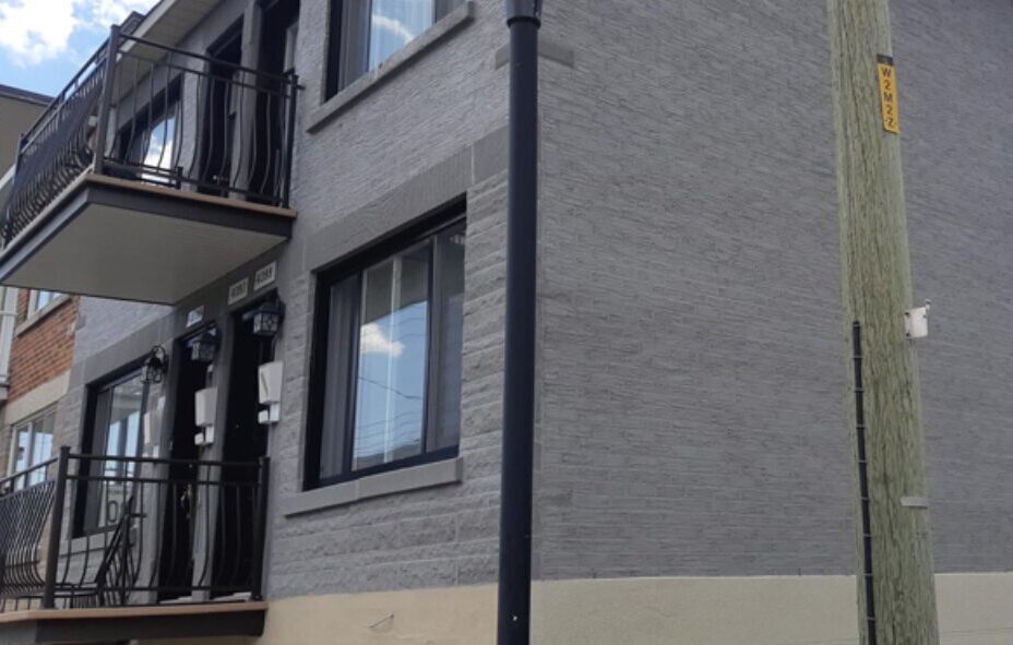 Façade en briques modernes d’un immeuble rénové par polo-maçonnerie à Auch, avec balcons et portes jumelées